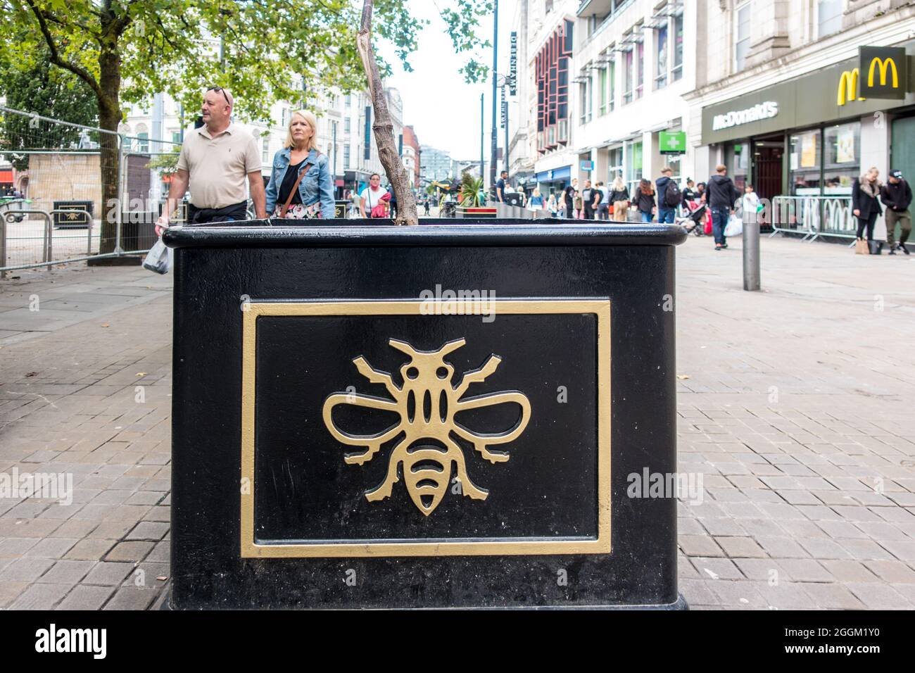 Manchester Bee symbol on road planters placed at the entrance of high street in Manchester City