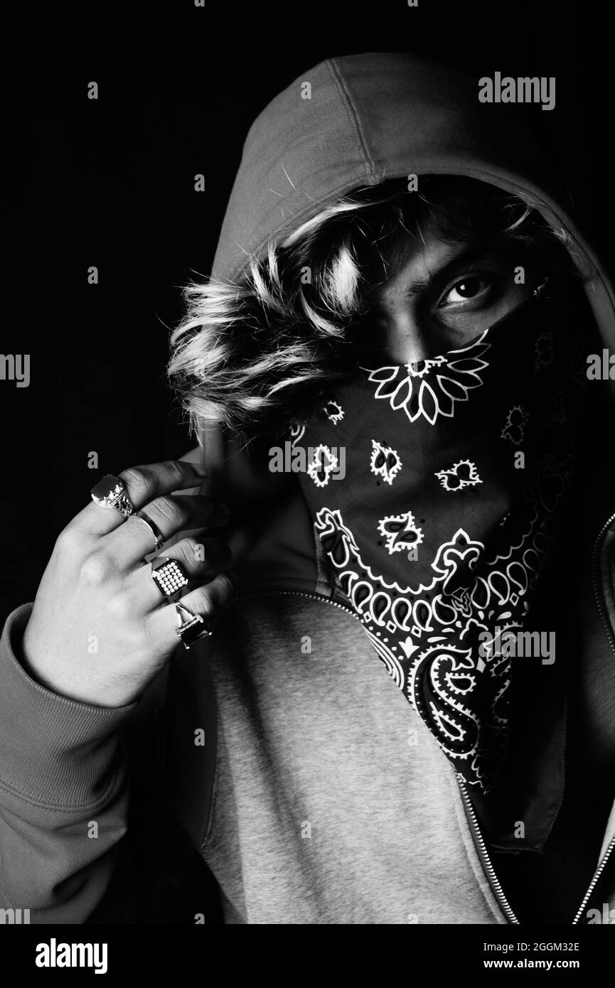 Grayscale shot of an Asian person wearing a hoodie and bandana Stock Photo