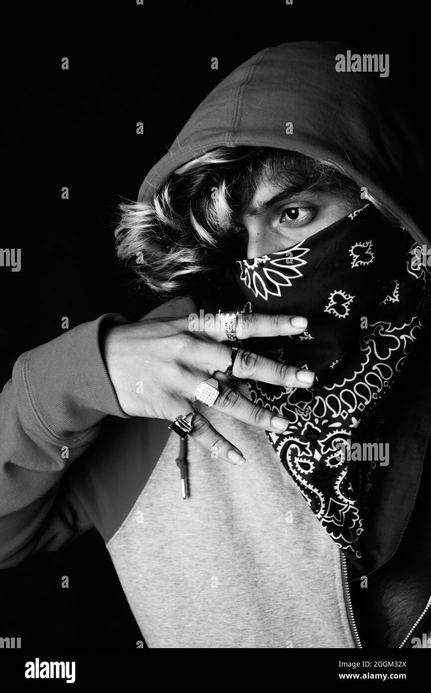 Grayscale shot of an Asian person wearing a hoodie and bandana Stock Photo