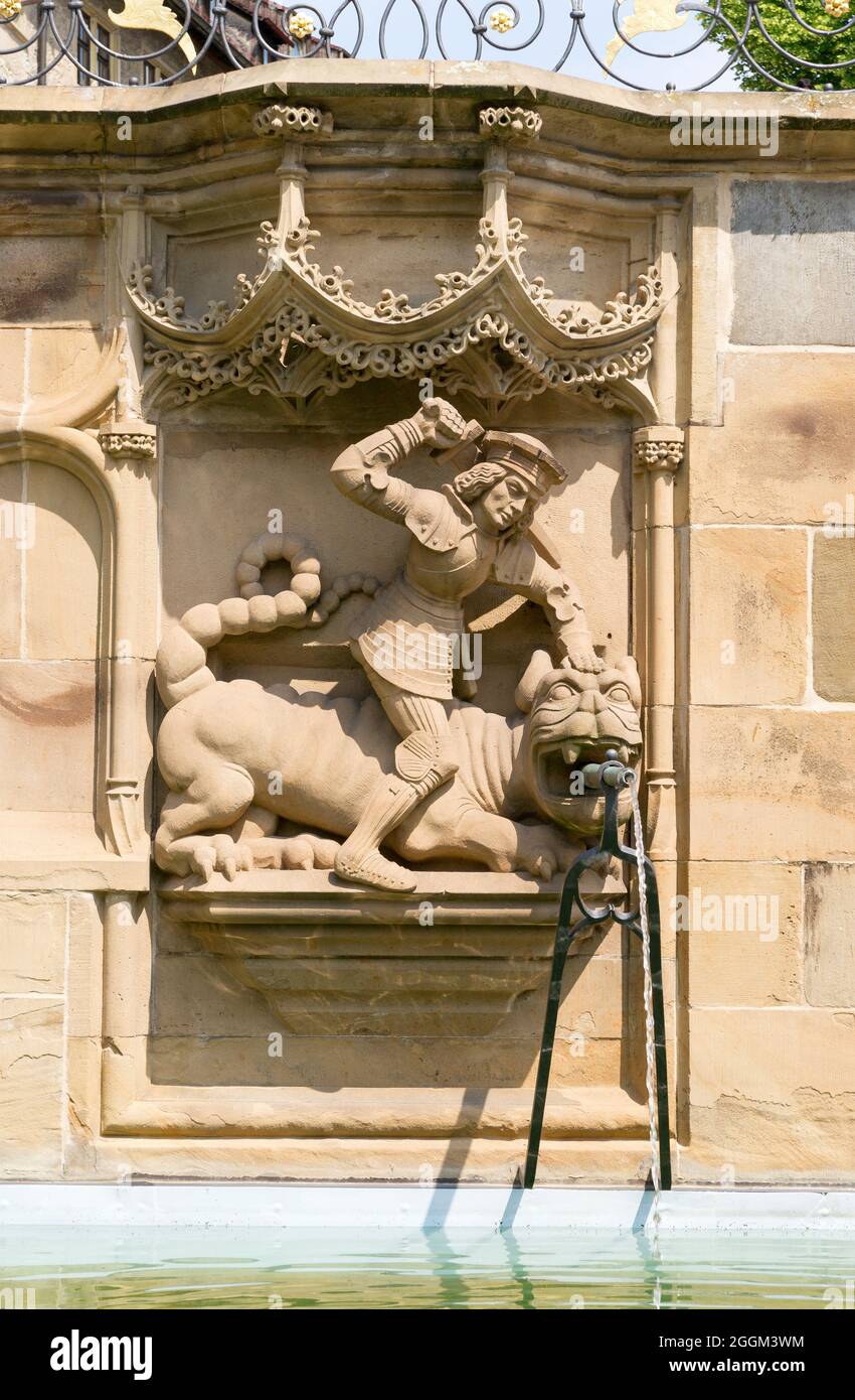 Germany, Baden-Wuerttemberg, Schwäbisch Hall, Saint Georg kills the lindworm, fountain figure from 1509 by the sculptor Hans Beuscher at the Gothic fish fountain. Stock Photo