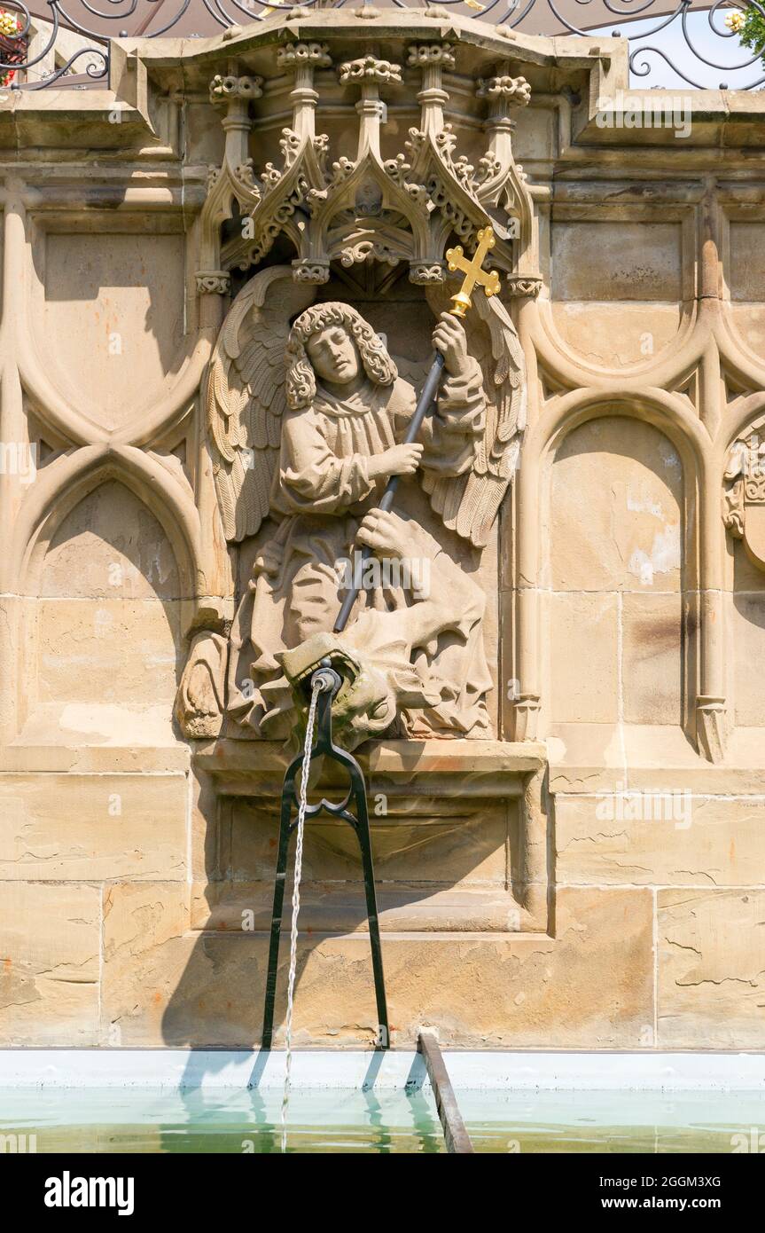 Germany, Baden-Wuerttemberg, Schwäbisch Hall, Archangel Michael, defeats the devil (dragon) and pushes him down to earth. Fountain figure from 1509 by the sculptor Hans Beuscher at the Gothic fish fountain. Stock Photo