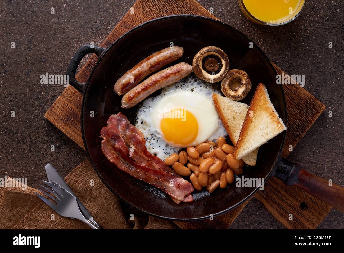 Irish fat morning breakfast with eggs, bacon, mushrooms, sausages, toast, beans and orange juice