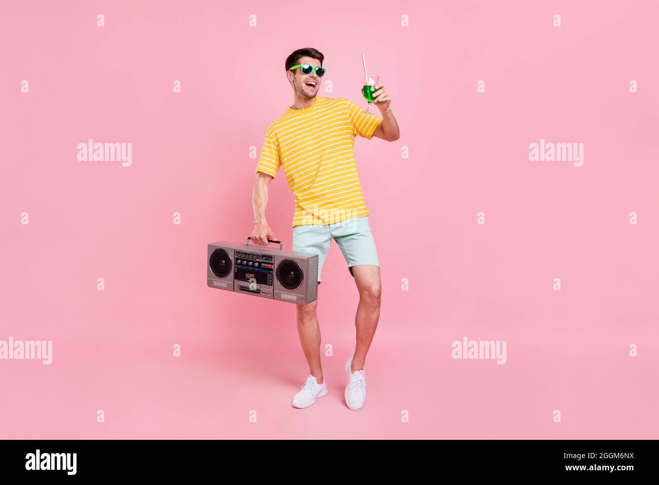 Full body photo of cheerful young happy man hold hand boombox cocktail