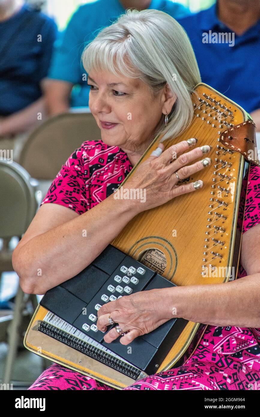 A senior lady autoharp player performing in the MidDay Mountain Music