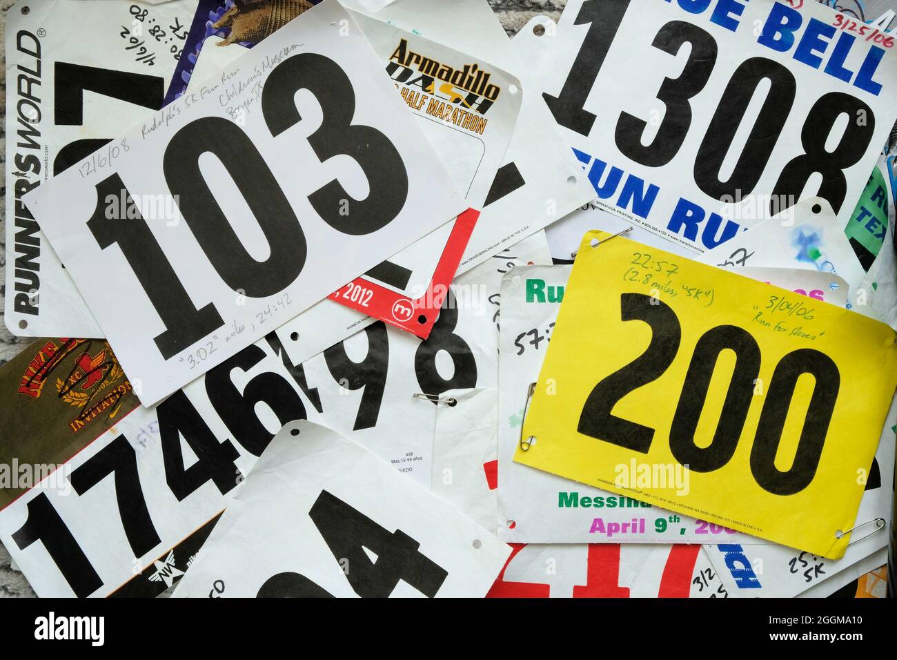 Assorted and random race bibs from 5k and 10k fun runs and competitive road races with handwritten results, times and dates; running bibs. Stock Photo