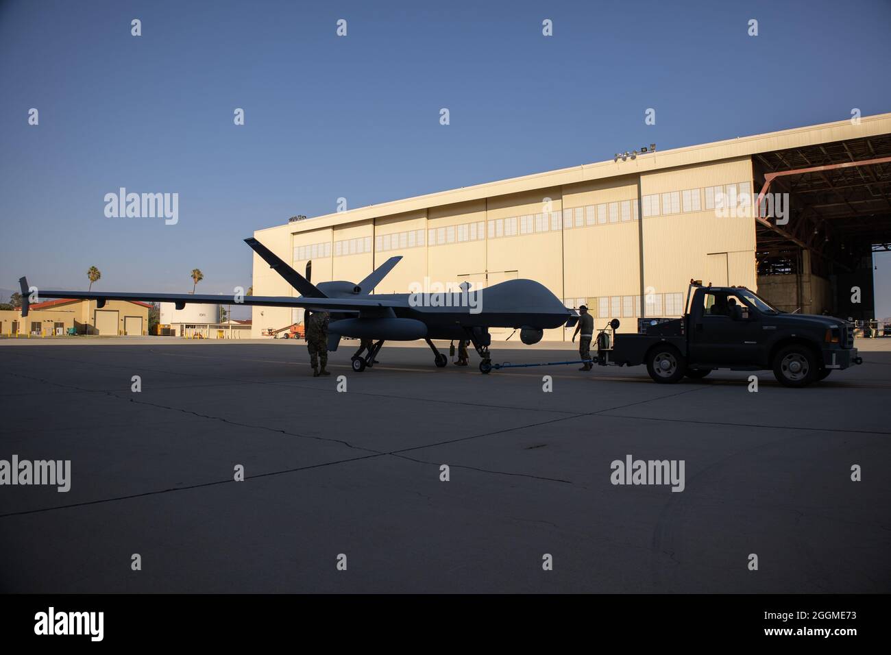 A U.S. Air Force MQ-9 Reaper remotely piloted aircraft assigned to the California Air National Guard’s 163d Attack Wing is towed out of the hangar, Aug. 9, 2021, at March Air Reserve Base, California, for a flight to map the Dixie Fire burning in northern California. The aircraft provides critical real-time data to firefighters and first responders so they can make informed decisions about how to contain the fire. (U.S. Air National Guard photo by Staff Sgt. Crystal Housman) Stock Photo