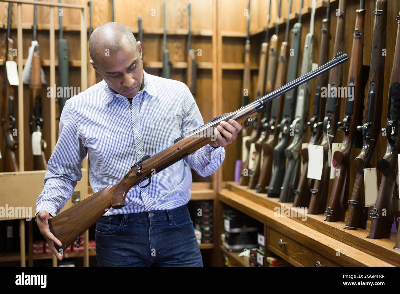 Portrait of owner of hunting shop standing with shotgun indoors Stock ...
