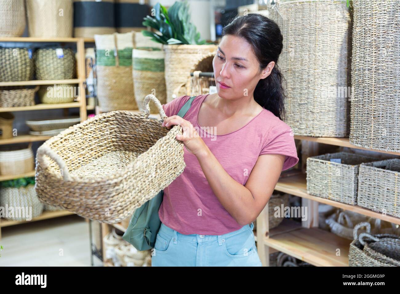 Woman choosing wicker basket in store Stock Photo Alamy
