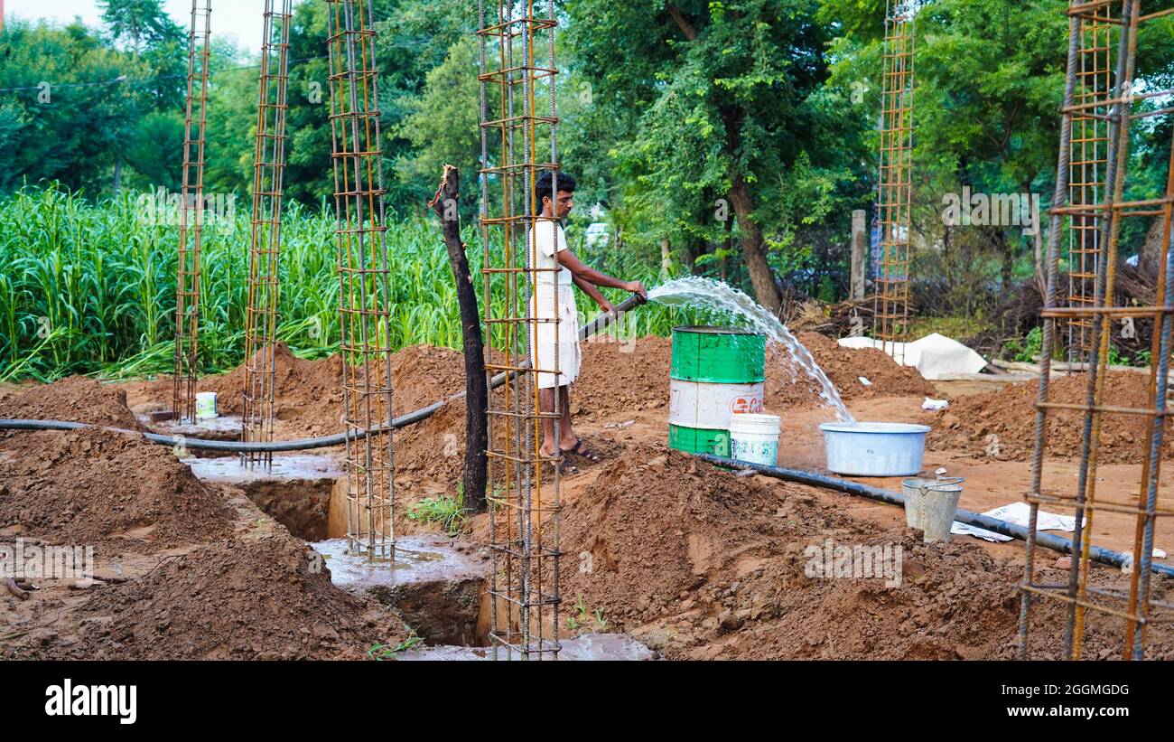 Indian man working on construction site. Building construction work goes in Jaipur, India. Rural India landscape. Stock Photo