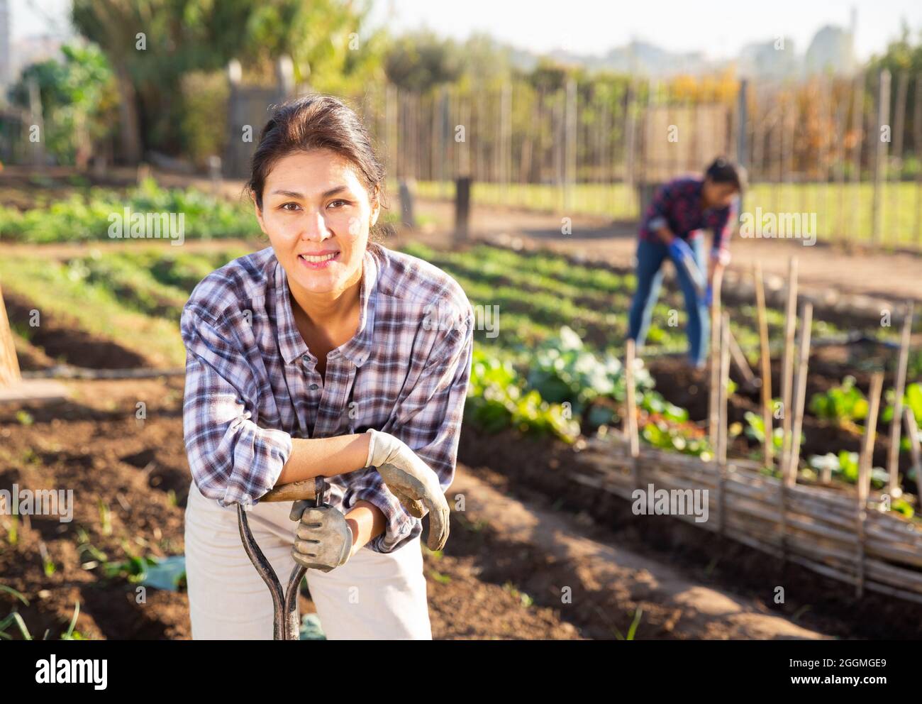 Positive female gardener posing in backyard garden Stock Photo - Alamy