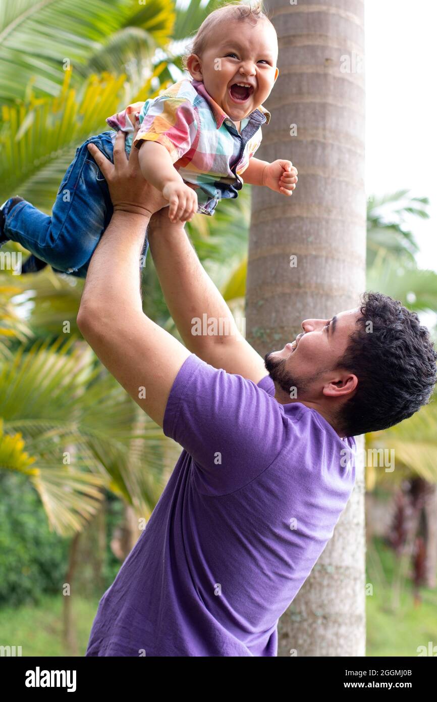 father holding his son high.baby smiling with her father Stock Photo