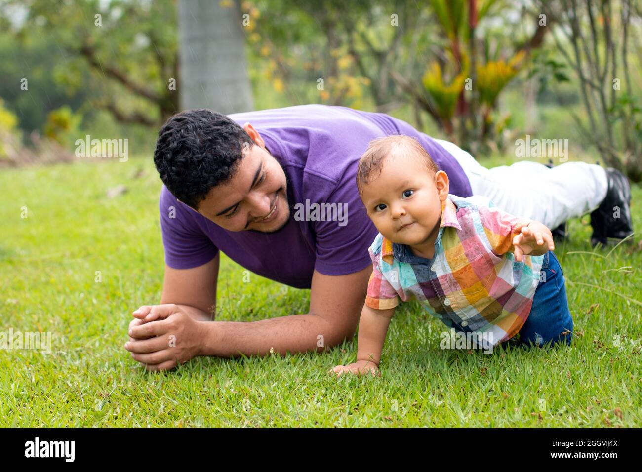 Dad and son playing on the lawn of a beautiful natural park Stock Photo