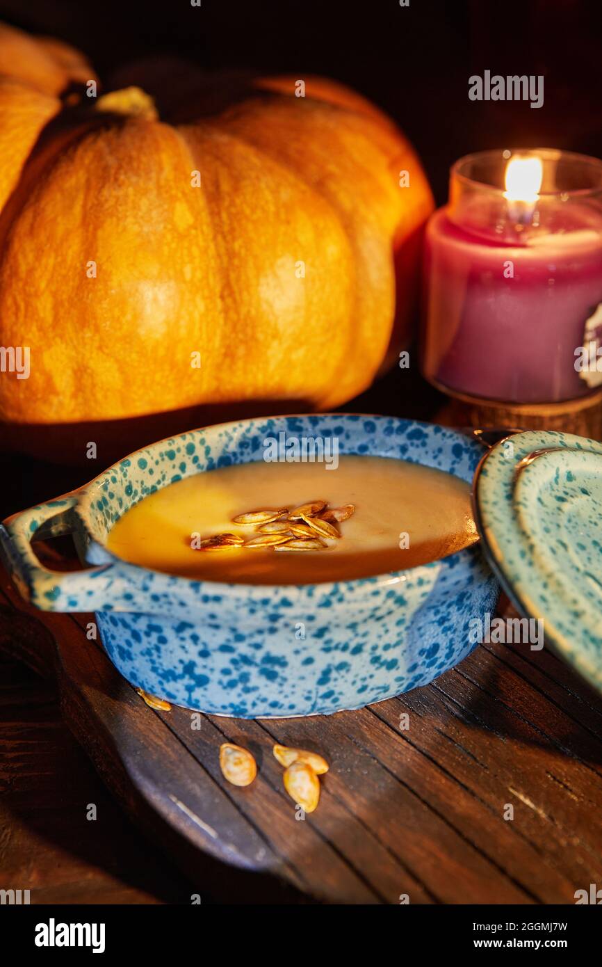 Halloween with candles with pumpkin and cream soup on spooky night - Halloween scene Stock Photo