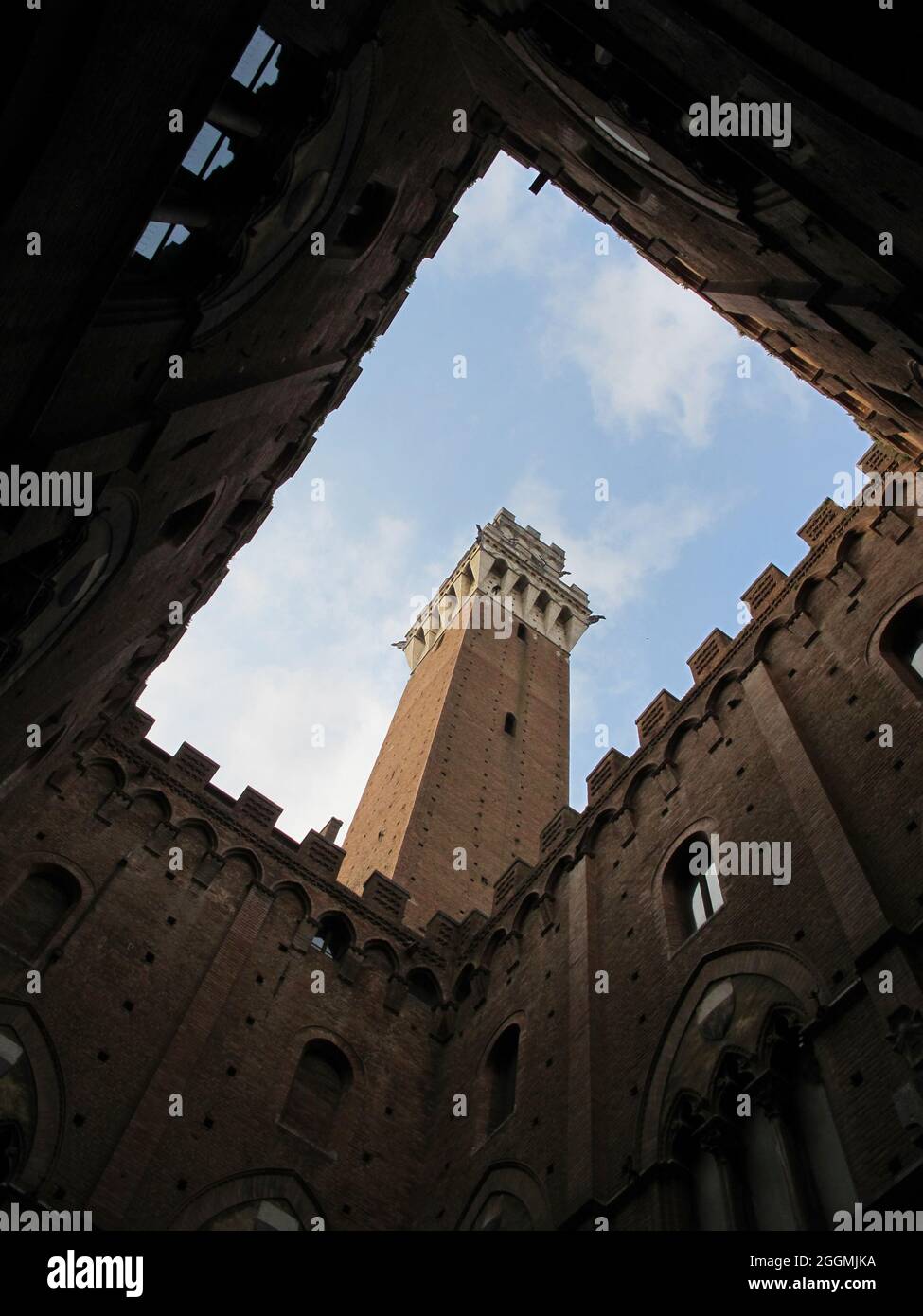 The historic Torre del Mangia of Siena, Italy - completed in 1348 - is shown from the courtyard of Palazzo Pubblico (Town Hall) during the day. Stock Photo