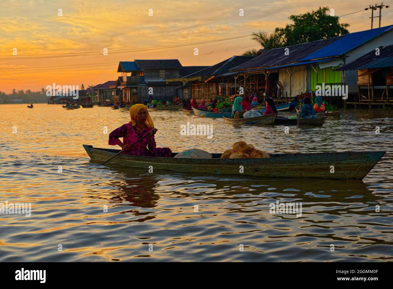 At sunrise all year round, the mostly female traders gather in their canoes (junking) to barter and trade an astonishing variety of home grown produce Stock Photo