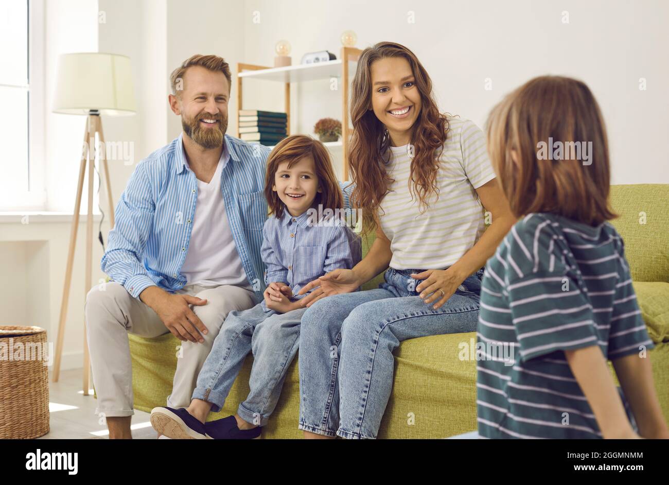 Happy smiley young mother, father and their little children all together at home Stock Photo