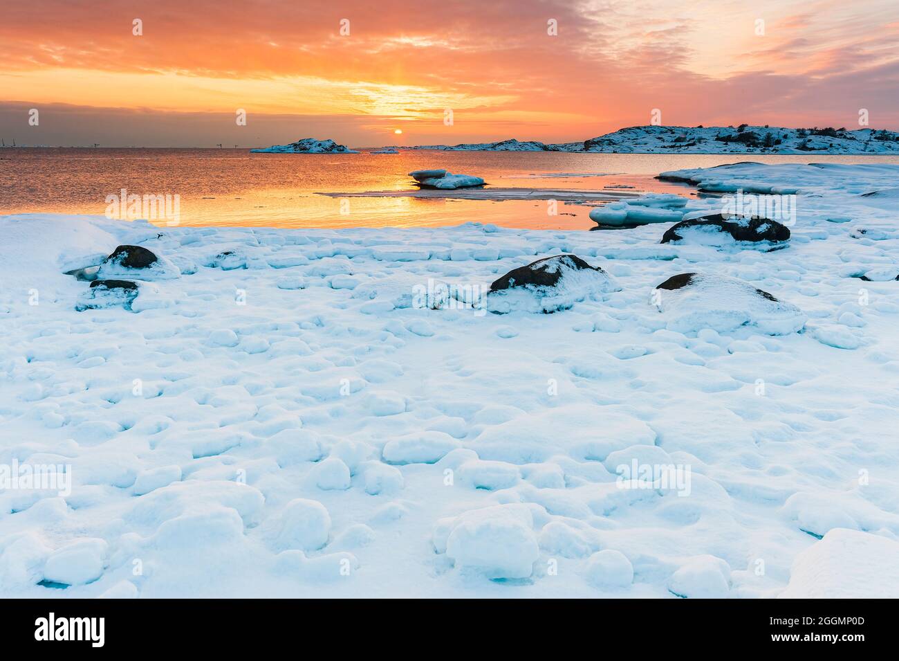 Snow covered coastal scene at sunset Stock Photo