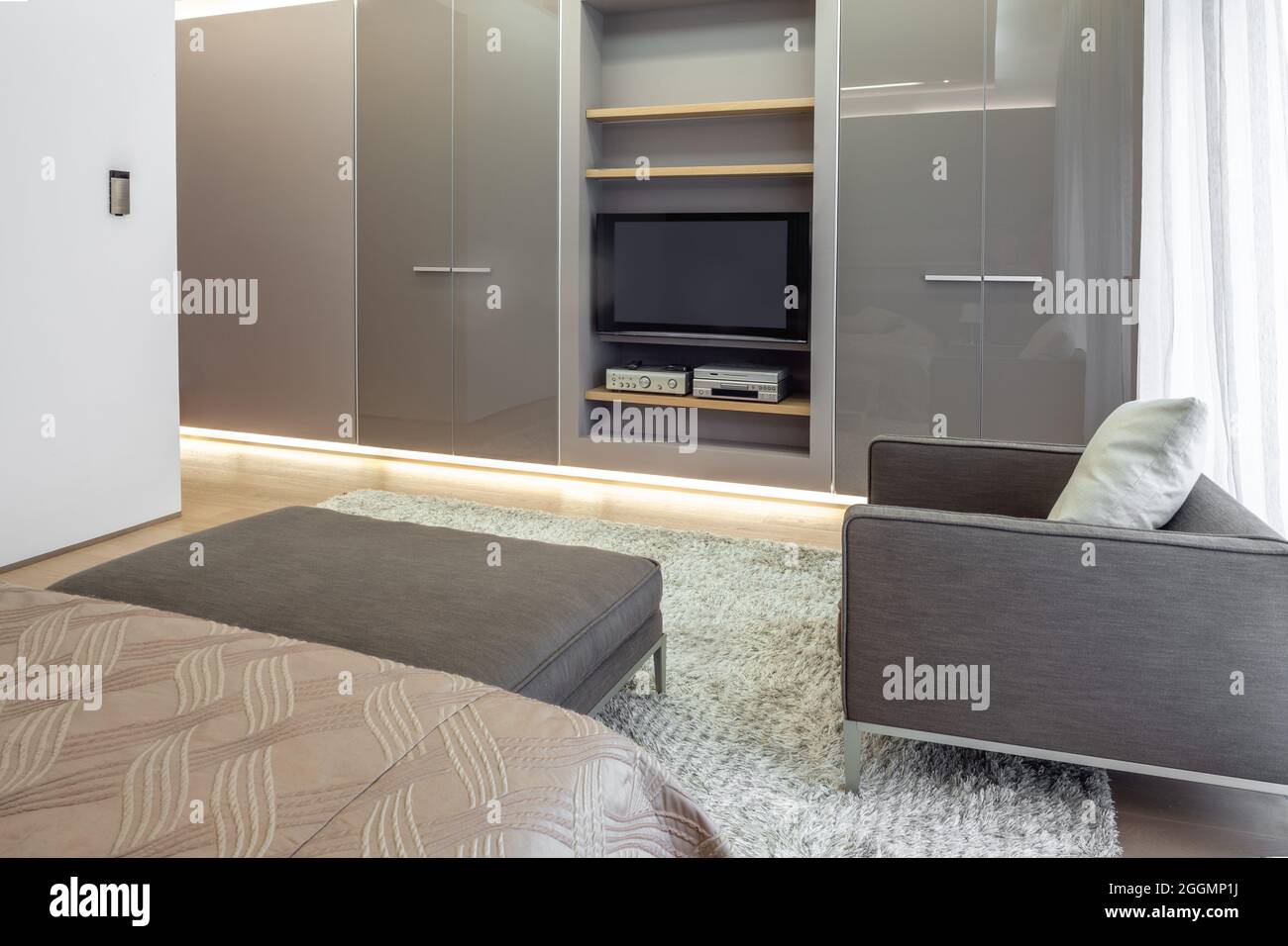 Bedroom equipped with builtin wardrobe with shelves for audio system