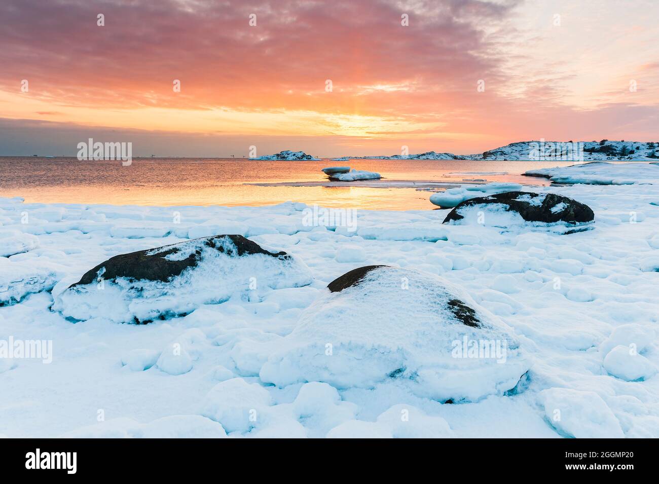 Snow covered coastal scene at sunset Stock Photo