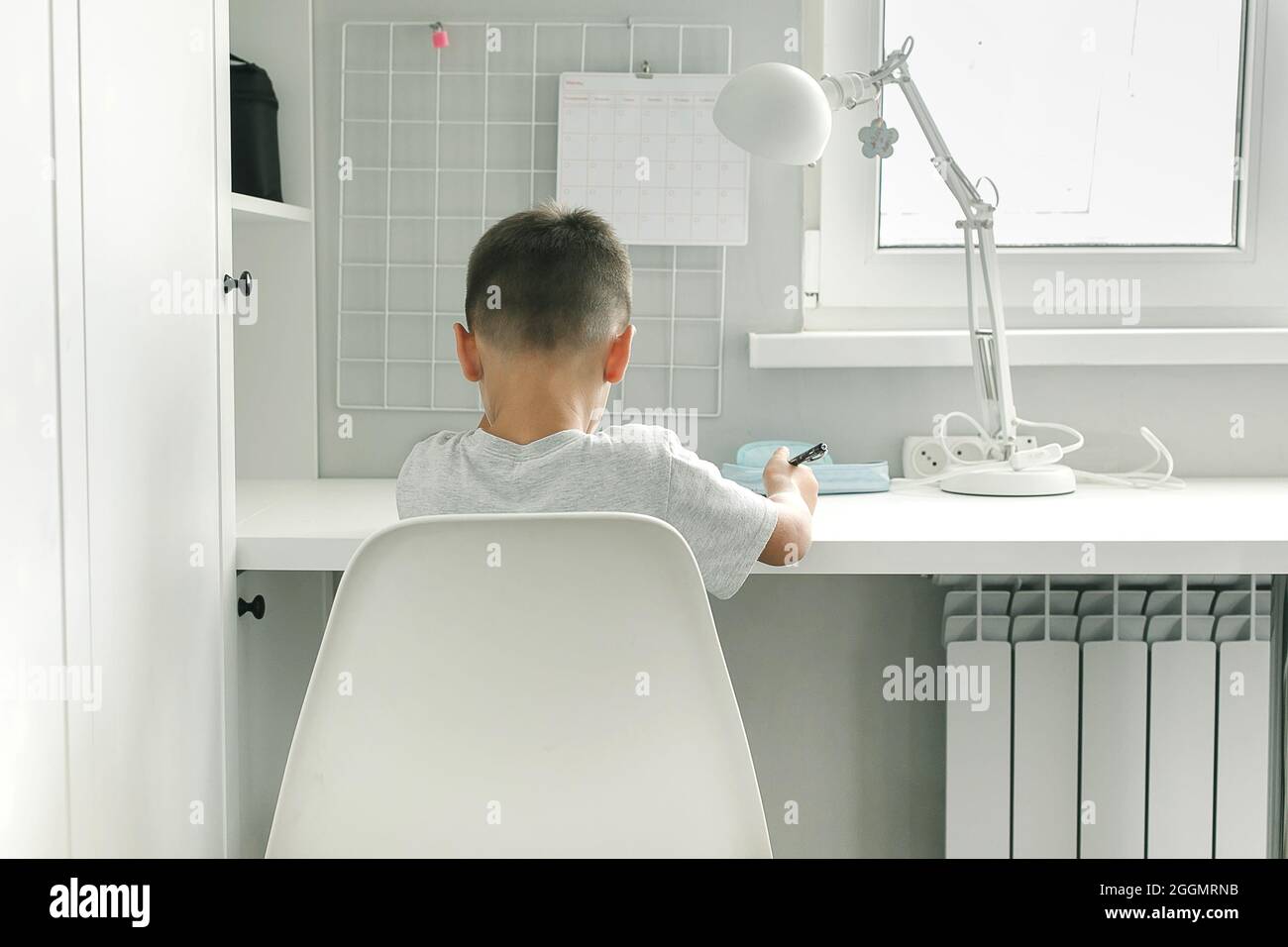 Concept of study distant from home. Caucasian boy doing school homework. Distance learning, online education Stock Photo