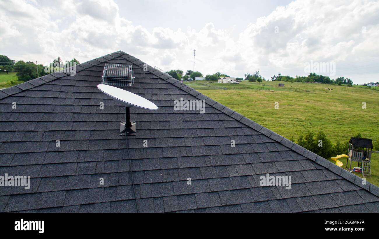 SpaceX Starlink satellite dish mounted on the roof of a rural home