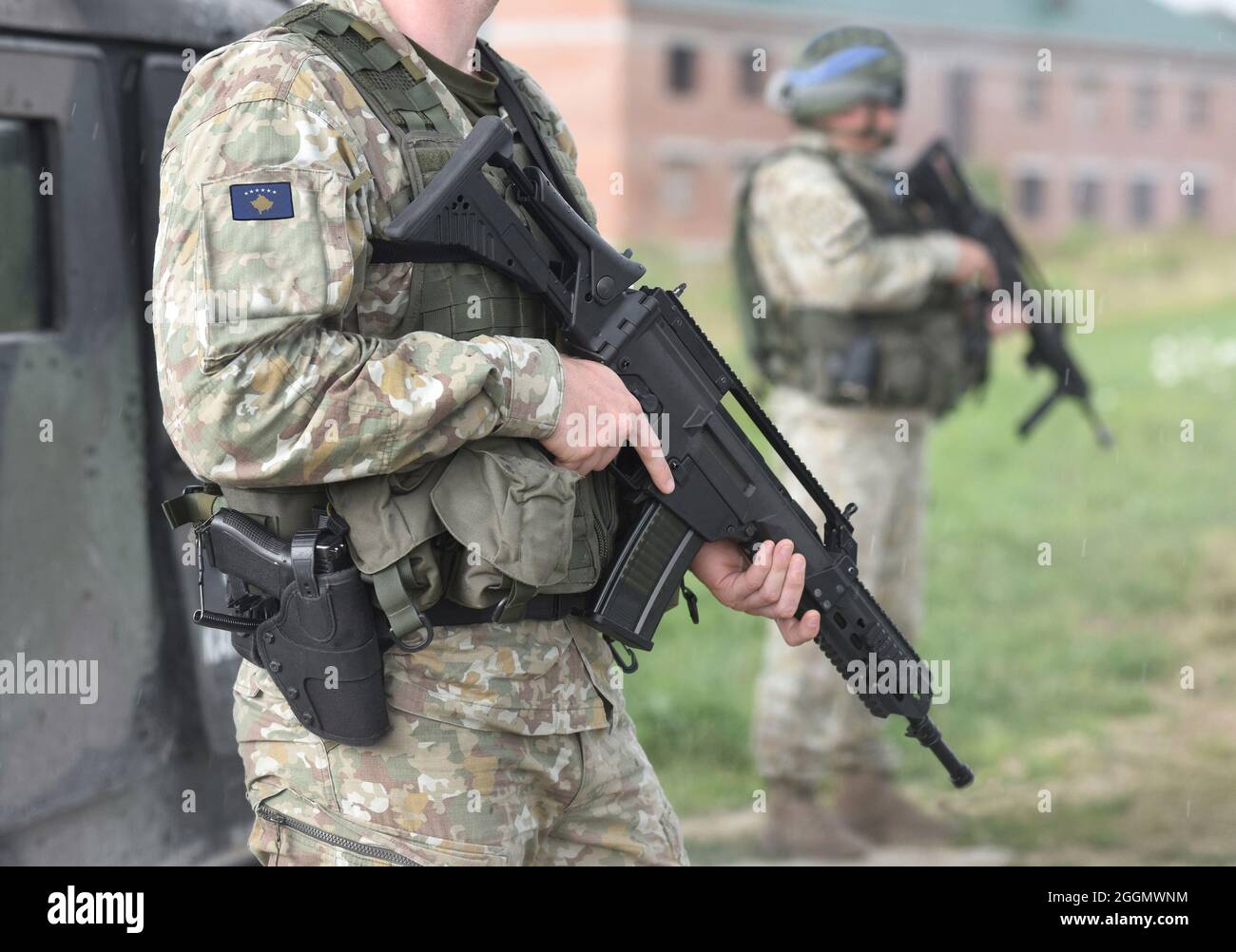 Soldiers with assault rifle and flag of Kosovo on military uniform. Collage. Stock Photo