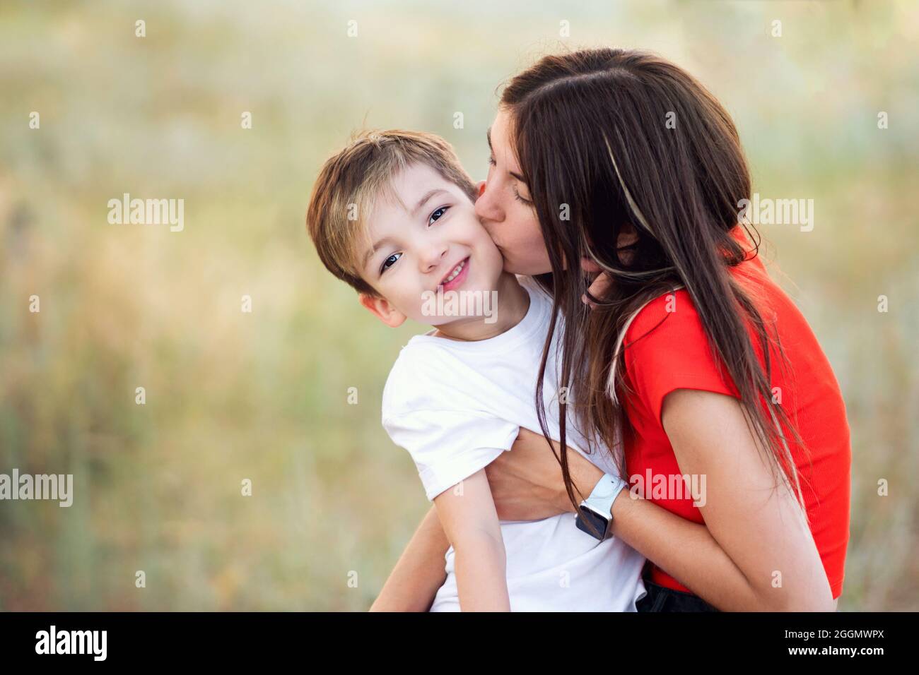 Mom Kissing on Cheek Smiling Son. Enjoying moment and Having Fun Together.  Loving Mother Spends Time with Little Child. Candid Portrait Authentic  Family Stock Photo - Alamy