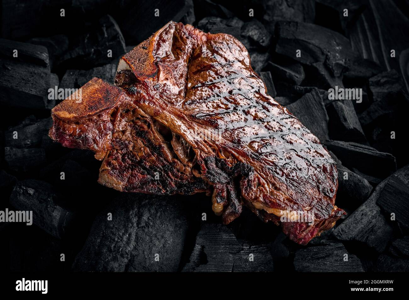 Grilling a tasty tender marinated tbone steak on a coals Stock Photo Alamy
