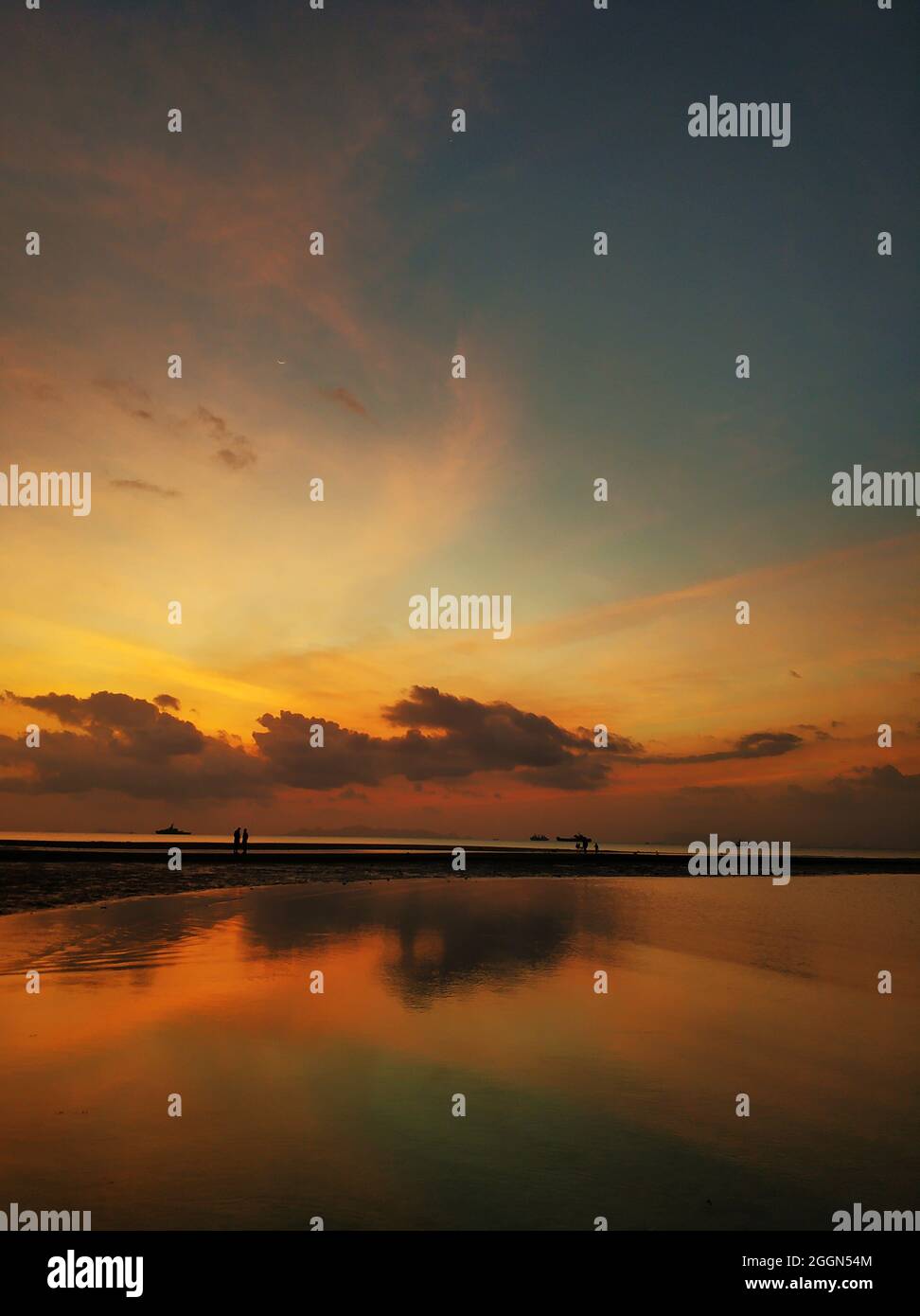Fiery sunset with clouds by the ocean Stock Photo - Alamy