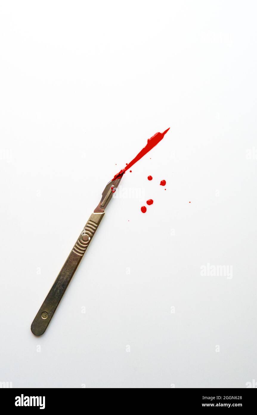 surgical scalpel with a cut and blood on a white background Stock Photo