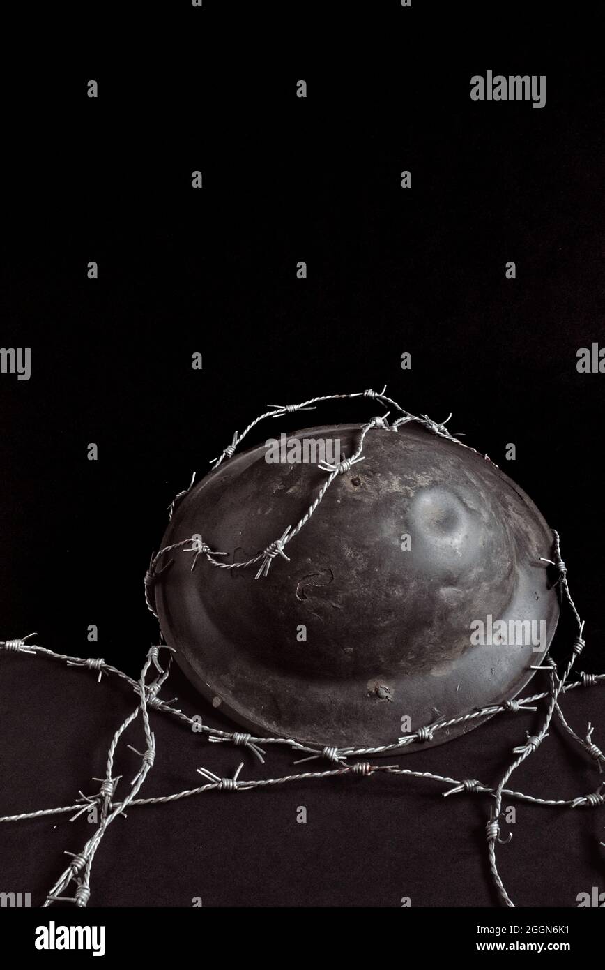 still life world war 1 soldiers steel helmet with barbed wire, black background. Poster, book cover? Stock Photo