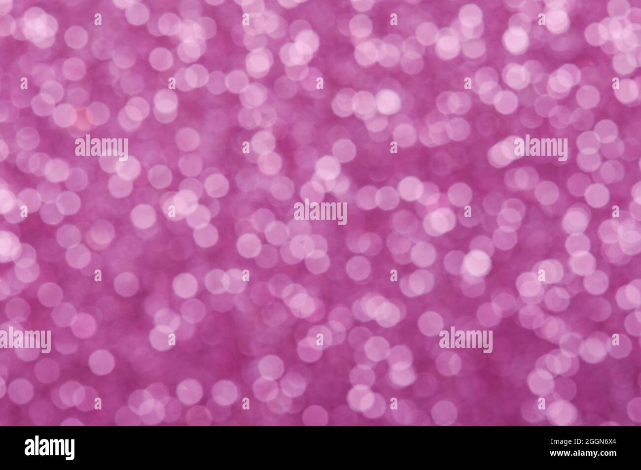 Blur sparkle white circles on pink background close up view Stock Photo