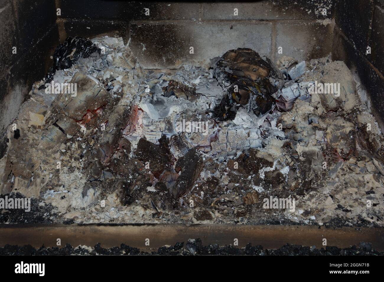 indoor wood burning stove fireplace with cold ash and shiny black soot after burning detail view