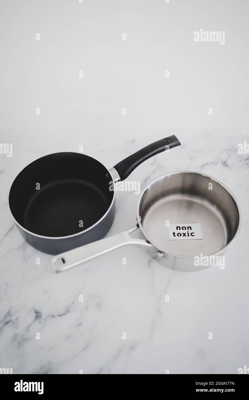healthy cooking and harsh chemicals concept, stainless steel vs non stick saucepan side by side