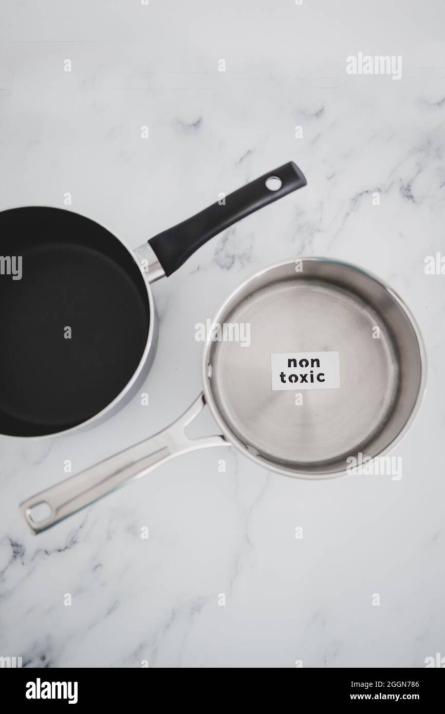 healthy cooking and harsh chemicals concept, stainless steel vs non stick saucepan side by side