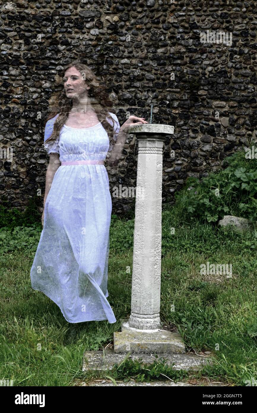 ghostly translucent woman in white haunting old church by sundial Stock Photo