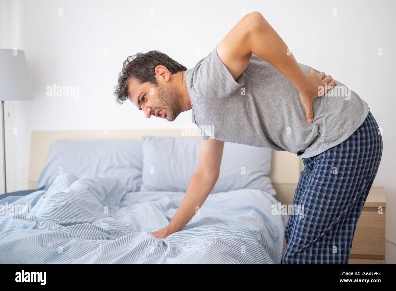 Man lying in bed and suffering from back pain Stock Photo Alamy