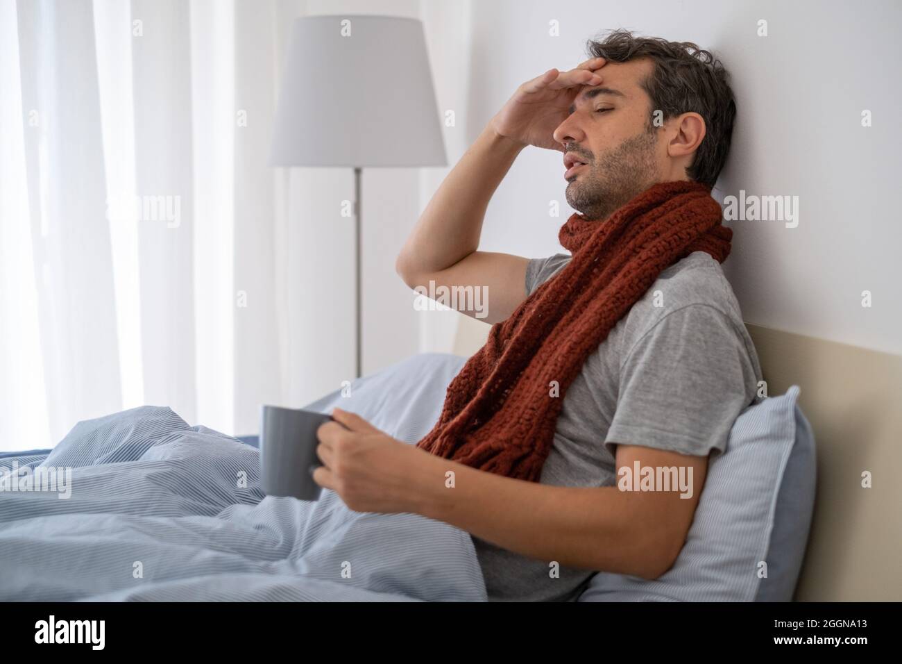 One man feeling fever symptoms and suffering in bed Stock Photo Alamy