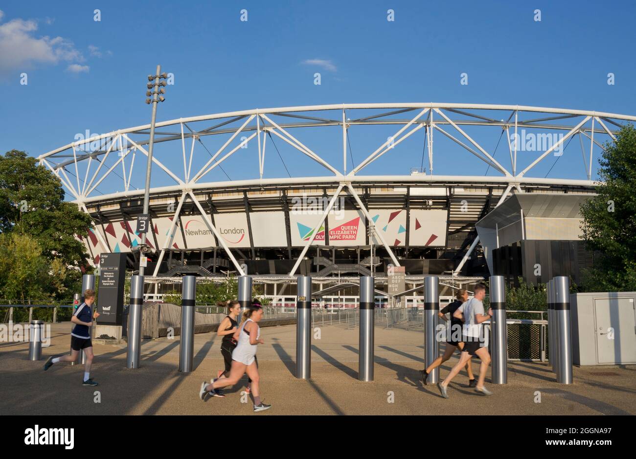 People joggin past the London Stadium by the Queen Elizabeth Olympic Park,London; England; UK Stock Photo