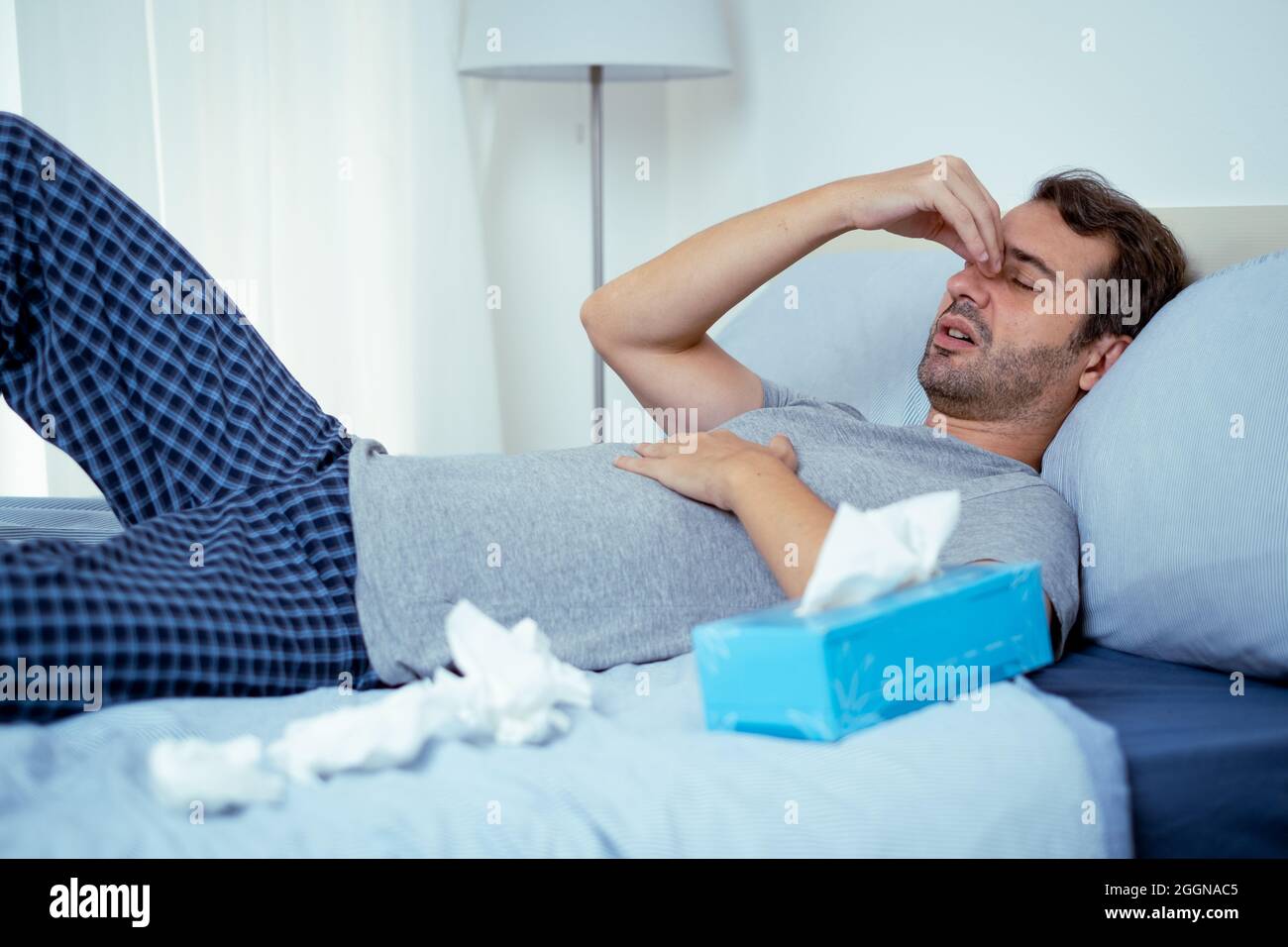 One man feeling fever symptoms and suffering in bed Stock Photo Alamy
