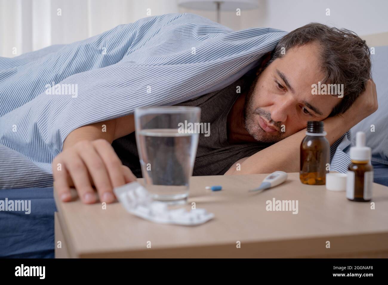 Sick man lying in the bed and feeling bad Stock Photo