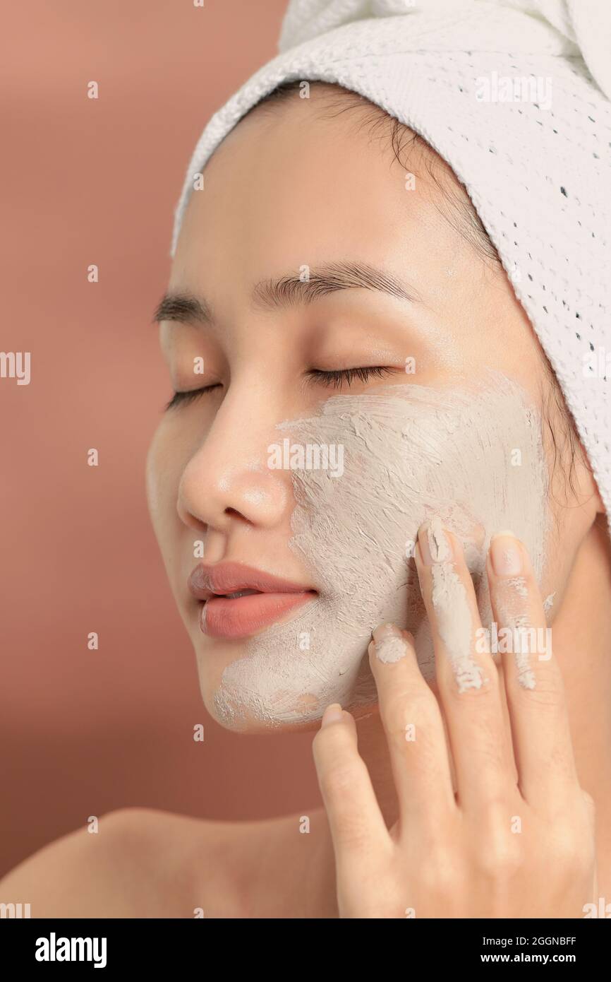 Spa Woman applying Facial clay Mask. Beauty Treatments. Stock Photo