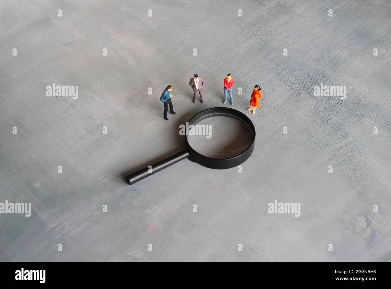 Concept of frequently asked questions, query, investigation, search for information. Miniature people looking at magnifying glass Stock Photo
