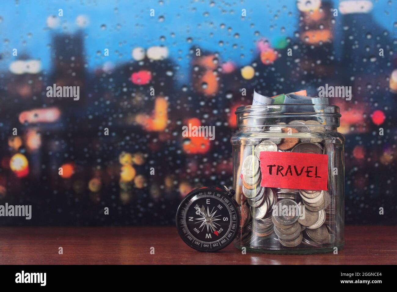 Travel budget concept. Travel money savings in a glass jar with compass. Copy space for text Stock Photo