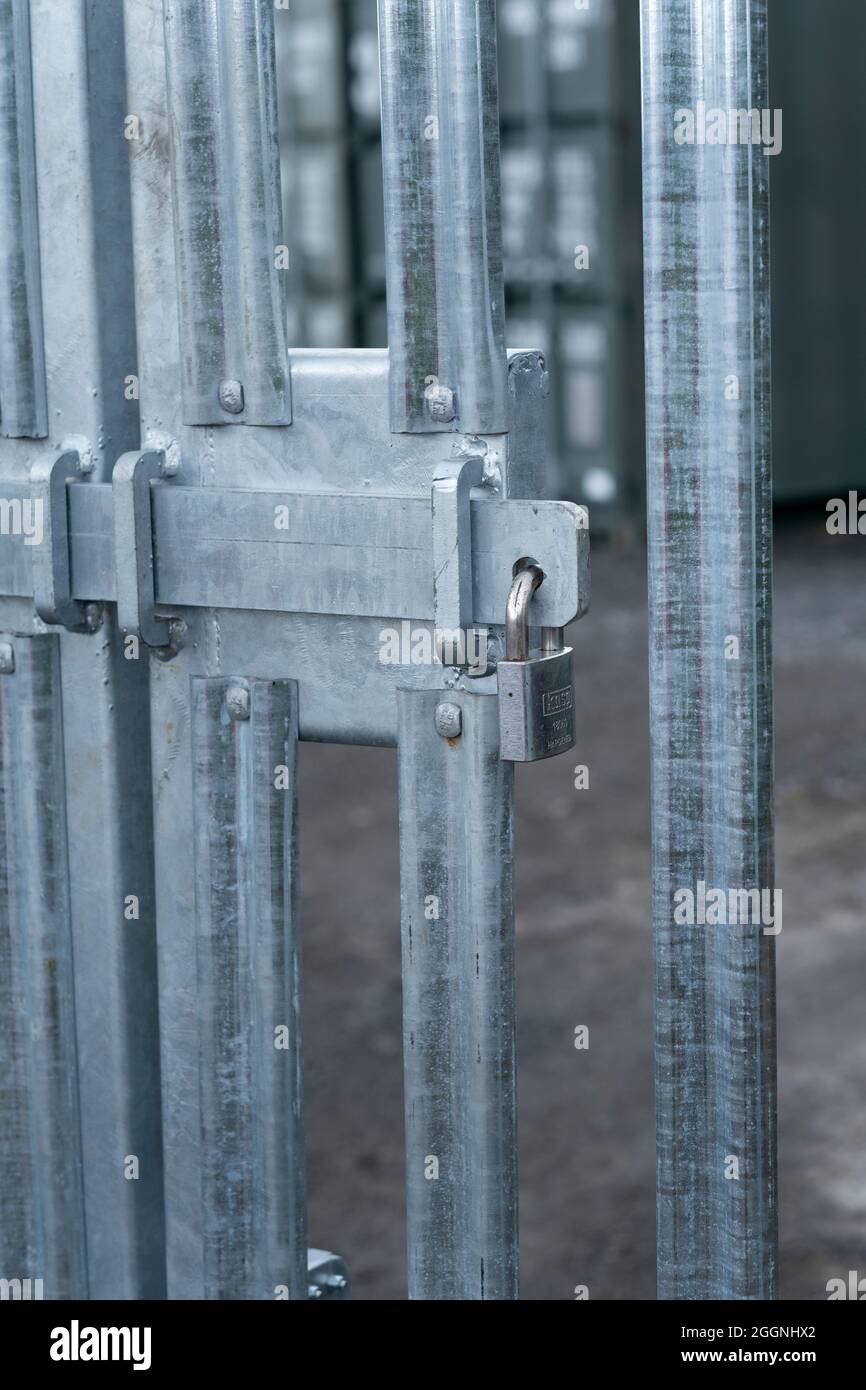 Security gate entrance locked with a padlock and sliding bolt Stock Photo