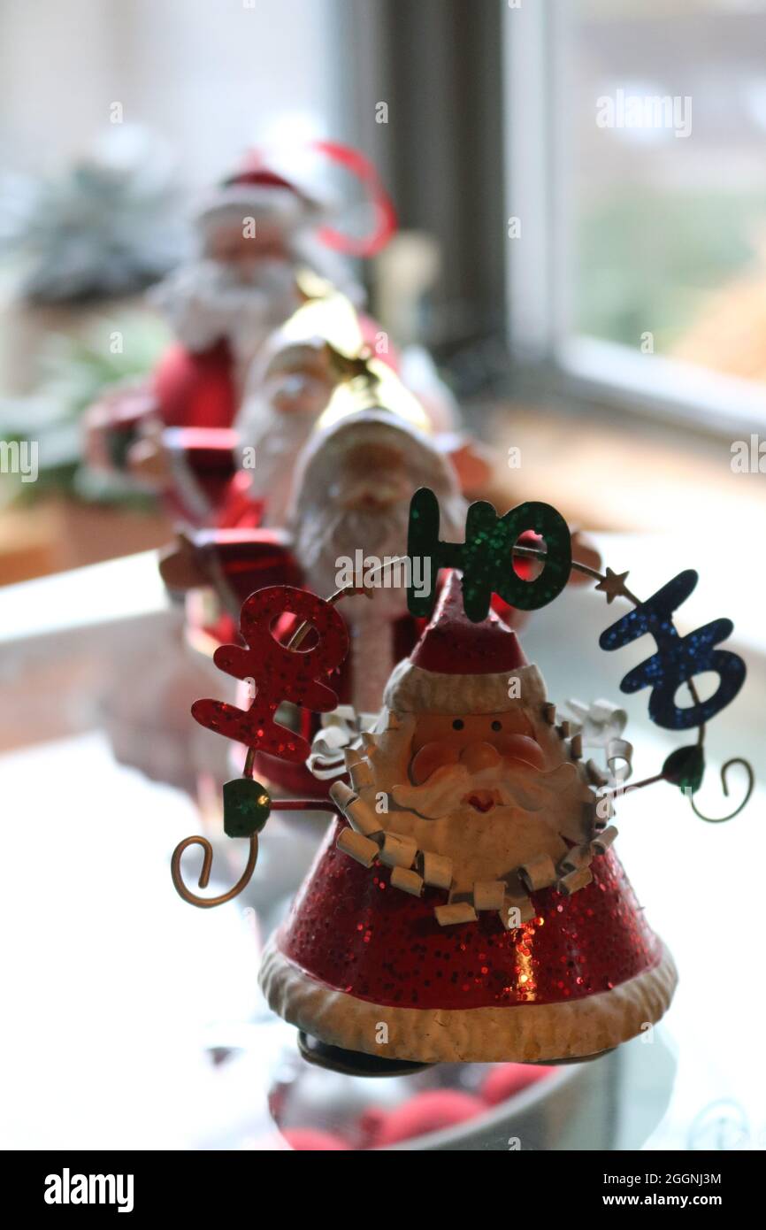 A windowsill with Four father Christmas ornaments in a row with Ho Ho on the first one Stock Photo