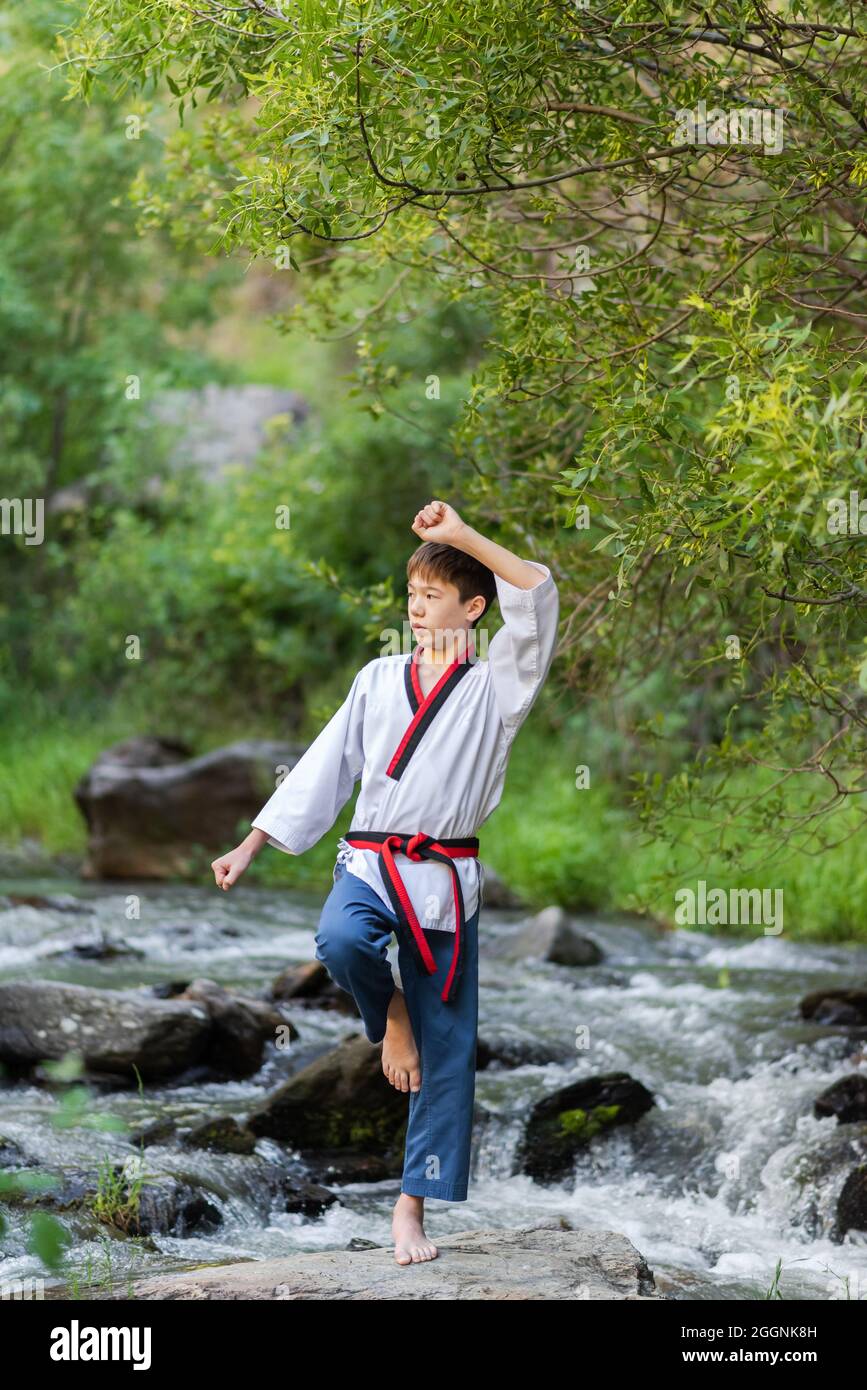 Portrait of a young boy doing balance exercise while practicing martial