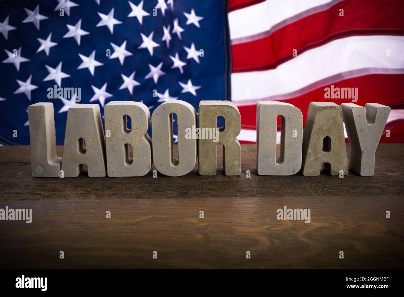 Happy Labor Day banner. USA flag and letters on rustic wooden background. Stock Photo
