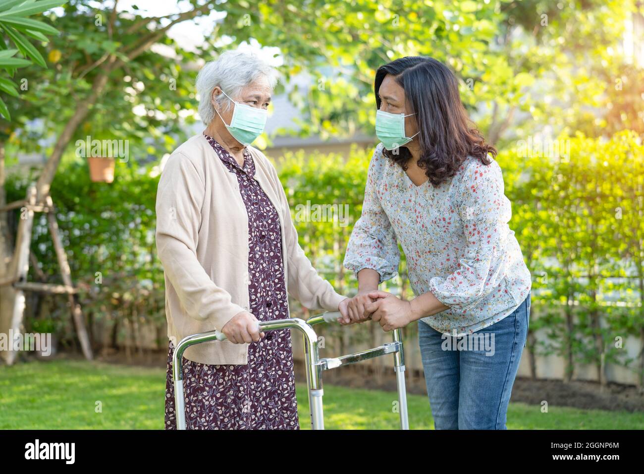 Asian senior or elderly old lady woman walk with walker and wearing a ...