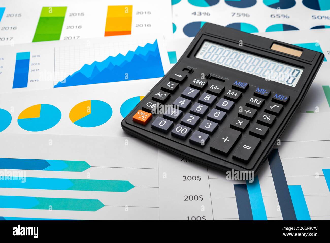 Business graphs paper and calculator on table Stock Photo